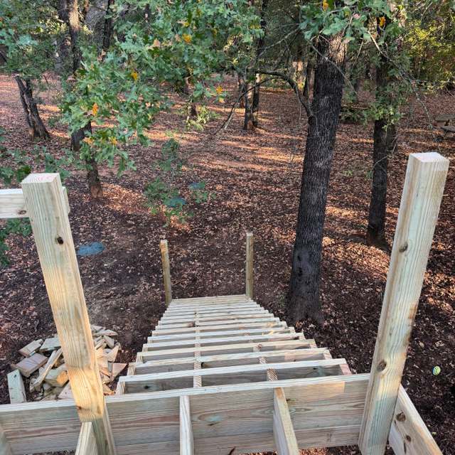 Deck stairs framed and landed to grade on a wooded lot
