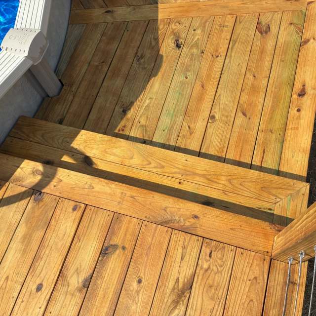 Step-down between deck levels beside a pool with cable railing