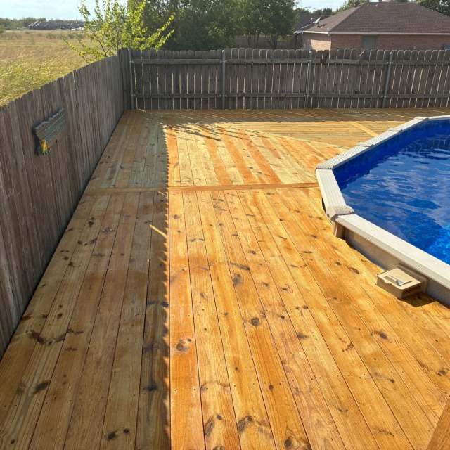 Stained deck along the fence beside an above-ground pool
