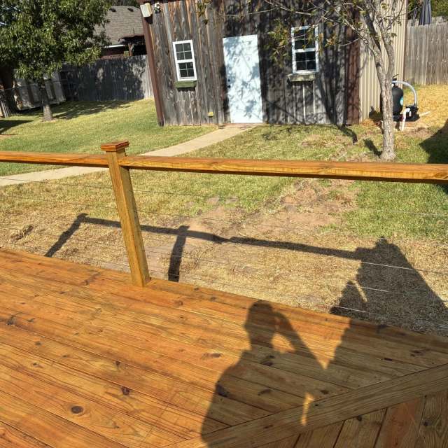 Cable railing with wood posts on a stained pool deck